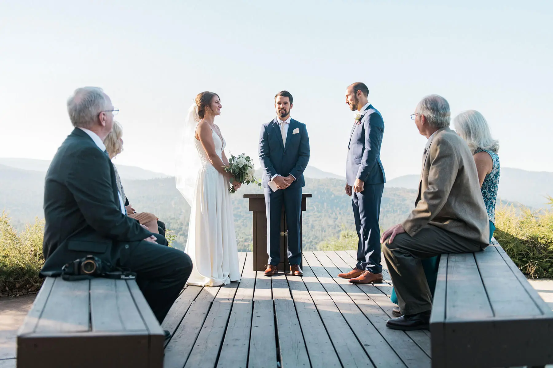 bride and groom standing on deck during intimate ceremony in oakhurst