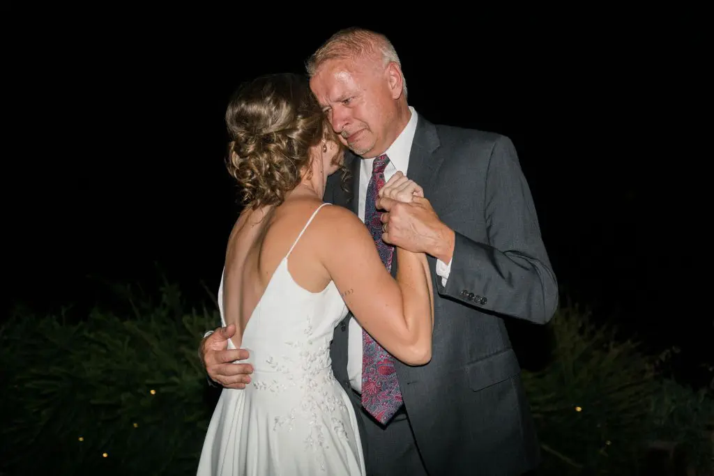 father cries while dancing with bride daughter
