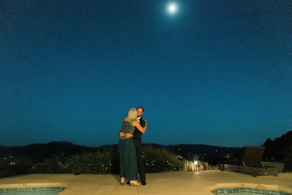 mother and son dancing under moonlight during intimate reception in oakhurst